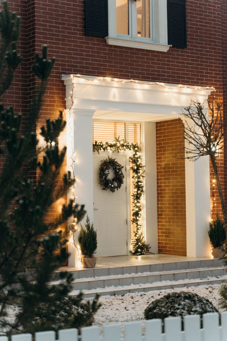 Huis met kerstverlichting en kerstkrans bij de voordeur